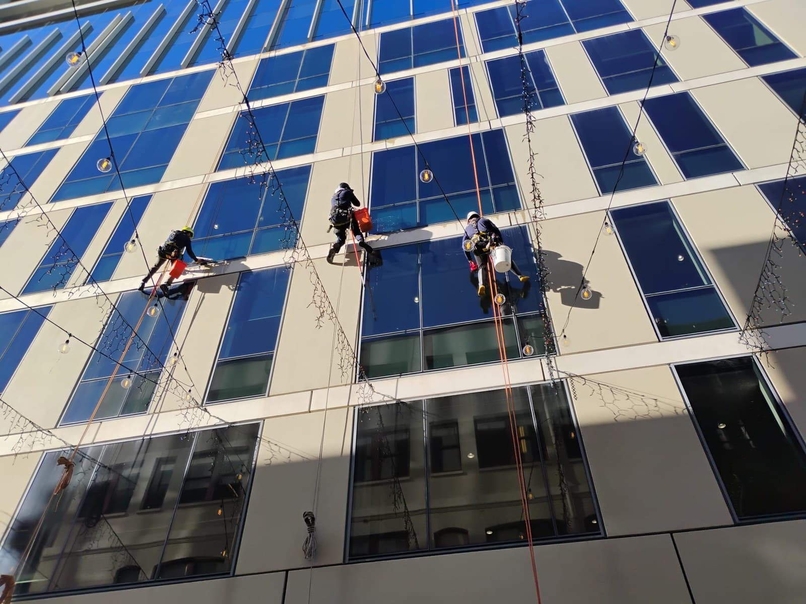 KMG rope access technician cleaning a commercial tower